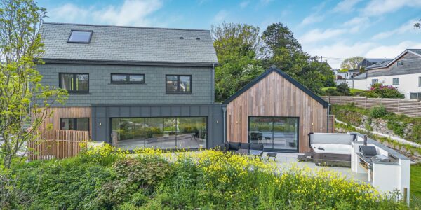 Contemporary house with large glass windows and wooden accents in Cornwall.