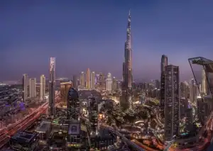 Night view of Dubai skyline featuring Burj Khalifa and surrounding skyscrapers.