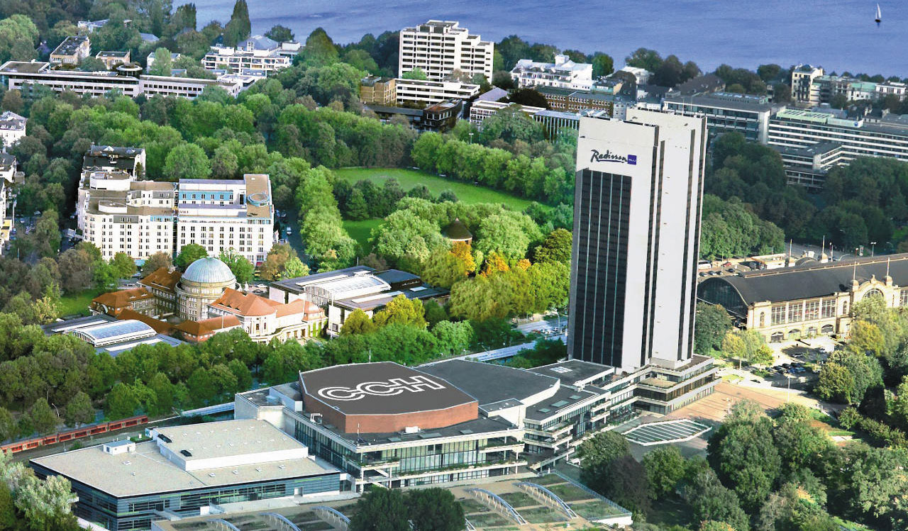 PMI by d2o hotel at sunset, modern urban skyline with lush green parks and waterfront views.