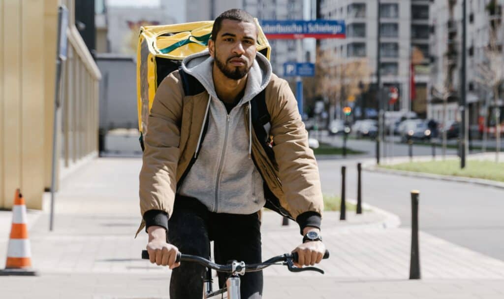 Livreur à vélo avec sac de livraison, transport urbain écologique.