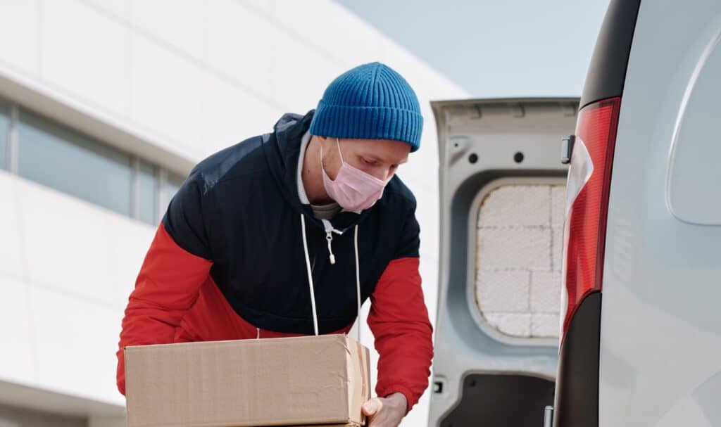 Homme chargeant un colis dans une camionnette, service de livraison fiable.