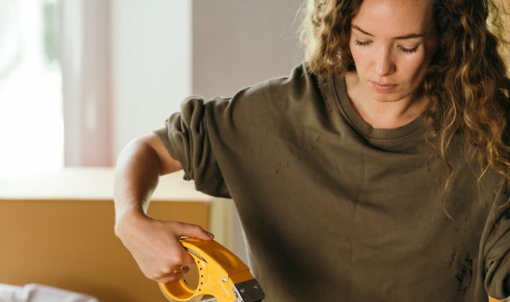 Femme utilisant un outil de bricolage dans une maison moderne.