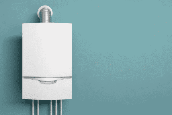 White wall-mounted boiler with visible pipes and a vent, set against a plain turquoise wall.