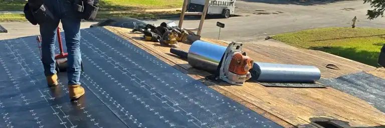 Roofing contractors installing self-adhering cap sheet membrane for best roof on flat roof