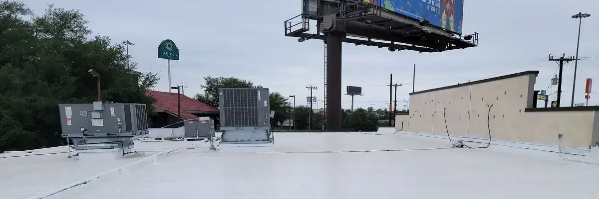 Flat commercial roof in San Antonio coated for waterproofing by Dolan Roofing & Construction, featuring HVAC units and smooth white coating