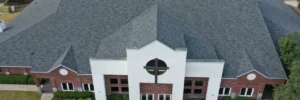 Large brick church with new gray asphalt shingle roof, highlighting church roof replacement San Antonio