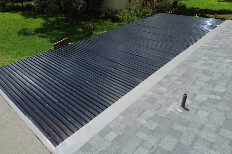 Restored metal roof panels and gray shingles after hail damage repair San Antonio by Dolan Roofing & Construction