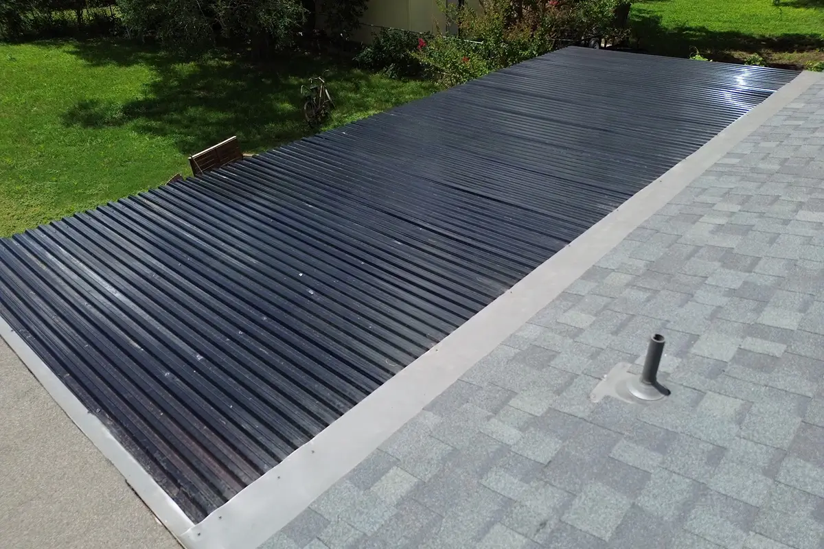 Restored metal roof panels and gray shingles after hail damage repair San Antonio by Dolan Roofing & Construction