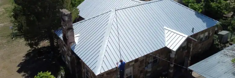 Aerial view of standing seam metal roof on stone house, demonstrating cost of metal roof in San Antonio