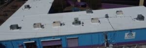 Aerial shot of a commercial building with a flat, white roof in San Antonio, TX