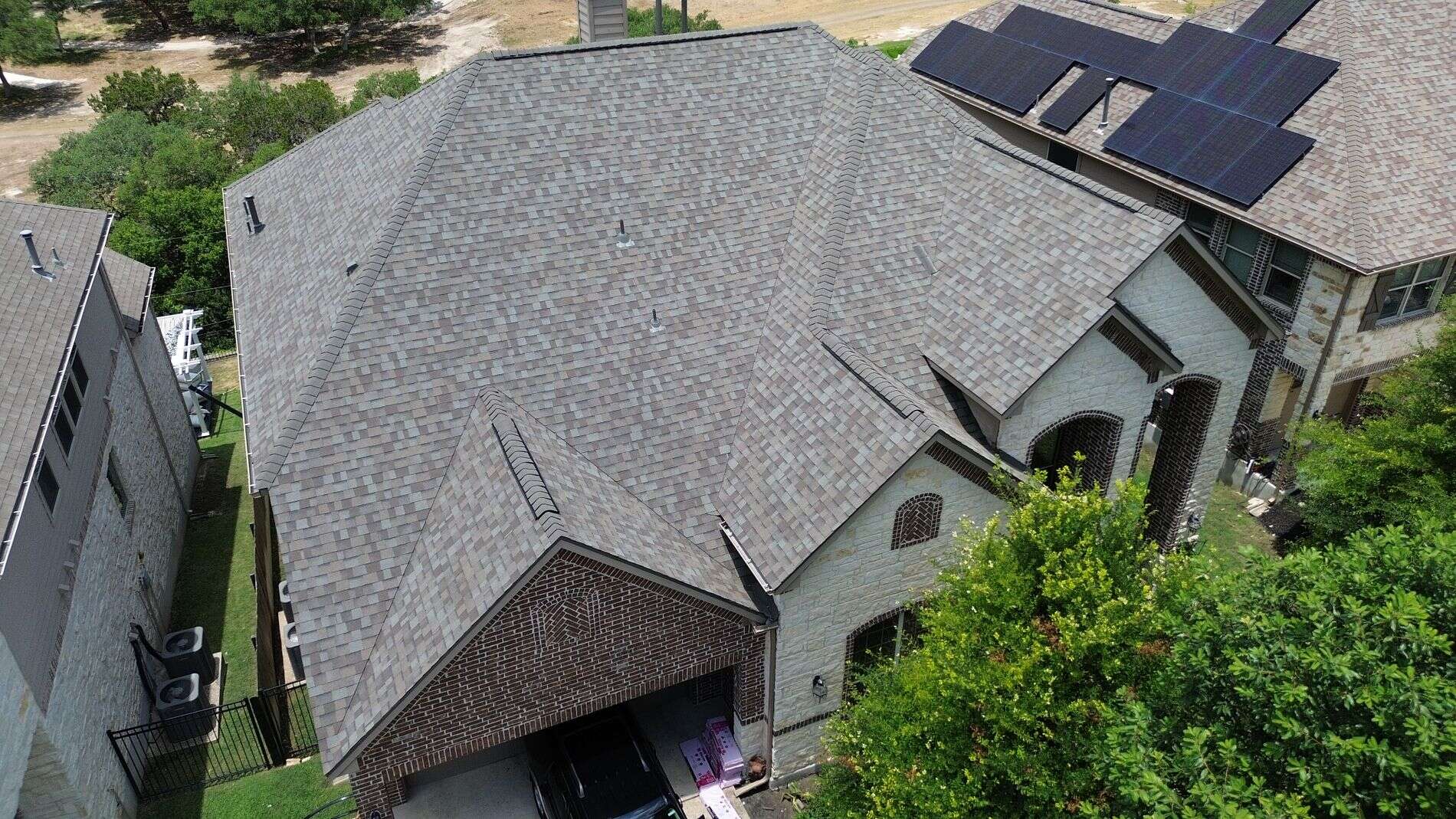 Aerial view of home featuring newly installed Owens Corning Duration Driftwood shingle roof by Dolan Roofing & Construction in Driftwood