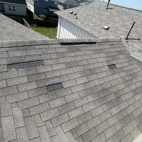 Roof with bent or displaced flashing indicating wind damage by Dolan Roofing & Construction