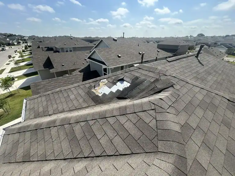 Missing and damaged shingles exposing underlayment as clear signs of roof wind damage by Dolan Roofing & Construction