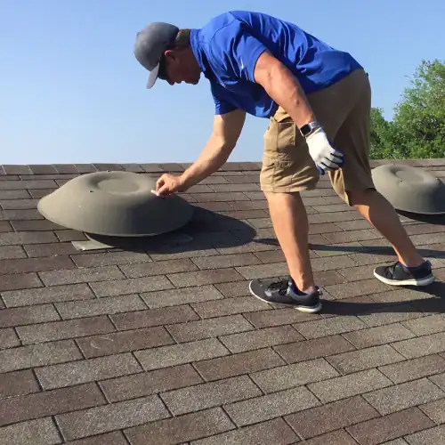 Roof inspector checking attic ventilation on asphalt shingle roof during replacement, demonstrating expertise among roofing companies in San Antonio TX and honoring the legacy of Johnny & his dad