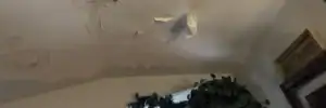 Ceiling with water stains and peeling paint, clear roof leak warning signs by Dolan Roofing & Construction in San Antonio