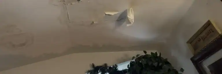 Ceiling with water stains and peeling paint, clear roof leak warning signs by Dolan Roofing & Construction in San Antonio
