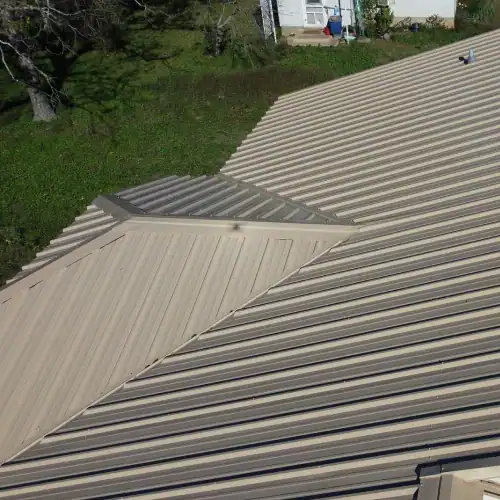 Tan standing seam metal roof on residential home, accentuating cost of metal roof San Antonio