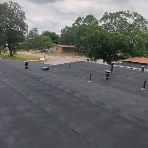 Newly installed black membrane flat roof on a commercial building in San Antonio, demonstrating the best roof for flat roof by Dolan Roofing & Construction