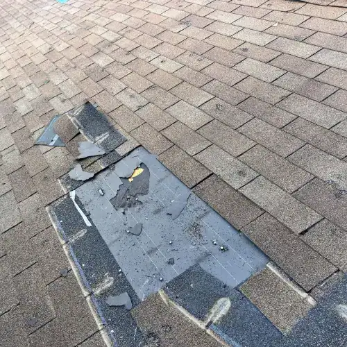 Close-up of a damaged asphalt shingle roof, illustrating the type of roof damage involved in actual cash value versus replacement cost roof insurance claims in San Antonio.