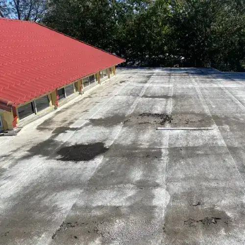 Flat commercial roof in San Antonio needing waterproofing, with visible patches and old roofing material