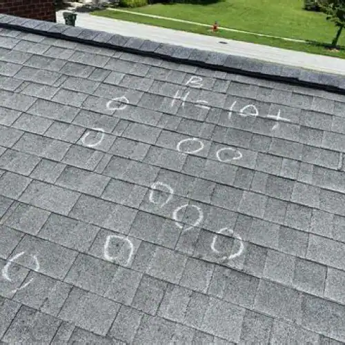 Roof with marked hail impacts during inspection, highlighting hail damage roof inspection by Dolan Roofing & Construction in San Antonio