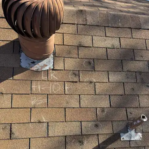 Hail damage inspection markings on roof shingles near metal vent in San Antonio