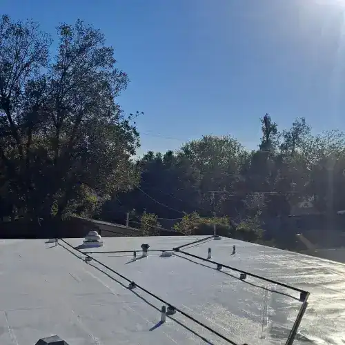 Commercial roof waterproofing project in San Antonio by Dolan Roofing & Construction, showcasing a newly sealed flat roof under clear blue skies.