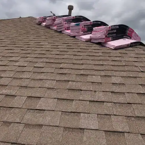 Stacks of roofing shingles staged on a residential roof, ready for installation following Texas storm roof inspection by Dolan Roofing & Construction in San Antonio