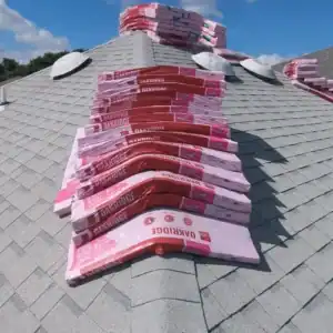 A hand holding a calculator with receipts, symbolizing the financial aspects of a roof replacement and the potential for tax benefits by Dolan Roofing & Construction in San Antonio