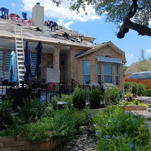A roofing crew from Dolan Roofing & Construction works on a residential roof, demonstrating the professional process for obtaining and completing roofing permits in San Antonio.