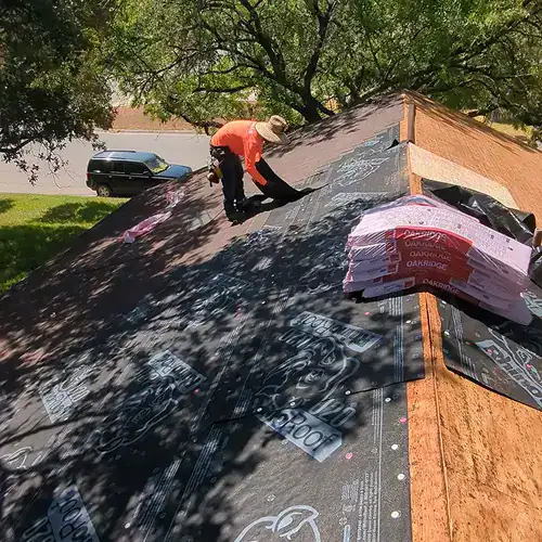 Professional roof repair in Seguin, TX by Dolan Roofing technician applying underlayment