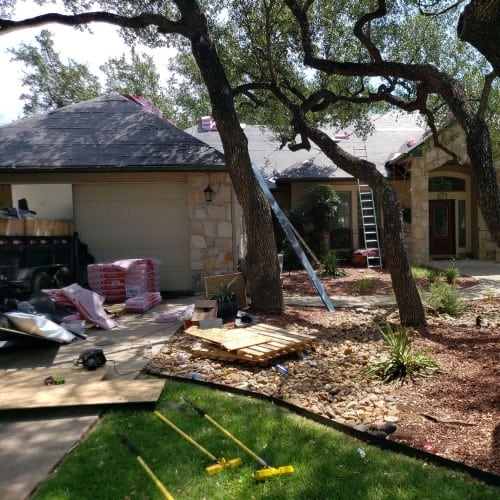 Roofing team installing new Owens Corning Oakridge shingles during exterior renovation by Dolan Roofing & Construction in Timberwood Park
