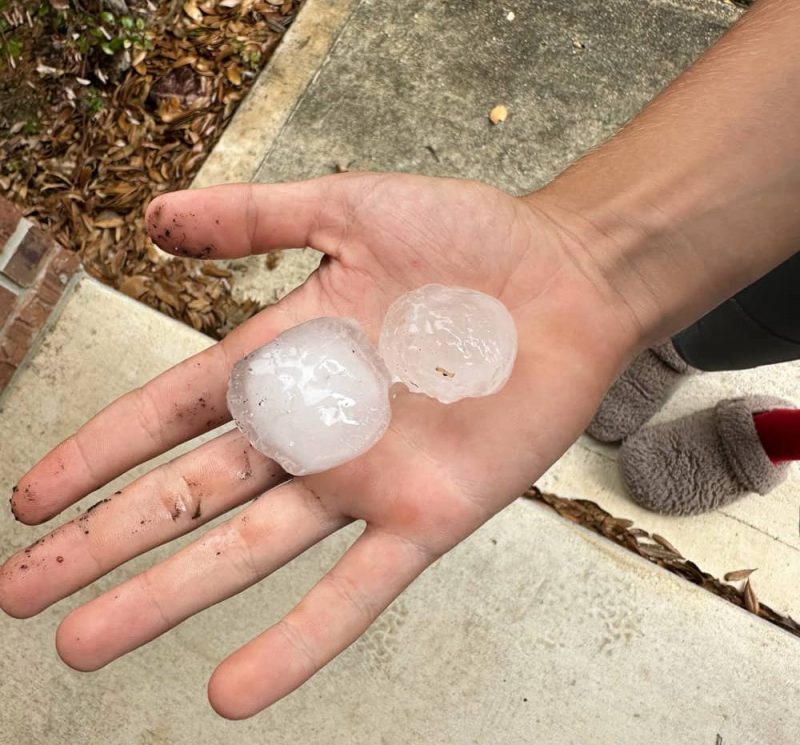 Large hail collected in palm during San Antonio storm, highlighting roof damage risk