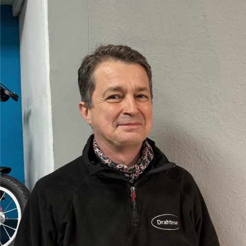 Mann in Drahtesel-Jacke vor neutraler Wand in Bad Schwartau.