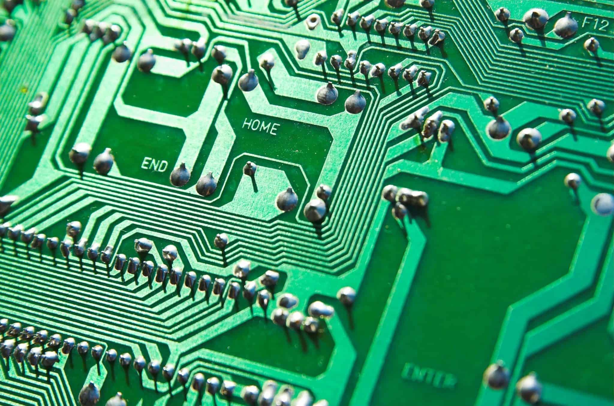 Detailed view of green circuit board with visible chips and pathways, highlighting technology elements.