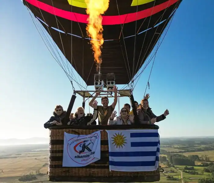 About us 3 grupo de viajeros de el kaminante volando en globo con la bandera de uruguay