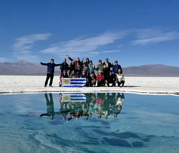 About us 2 grupo de viajeros de el kaminante posando con la bandera de uruguay