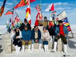 Bandera en la Antártida con grupo de turistas y banderas internacionales.