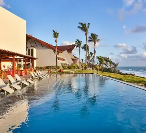 Disfruta de una piscina infinita con vista al mar en un resort tropical en Uruguay.