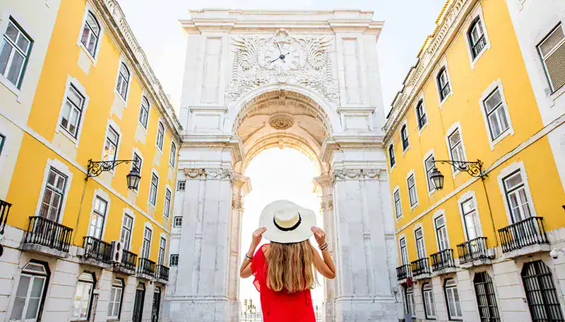 Una mujer con sombrero en la Plaza del Comercio, Lisboa, Portugal.