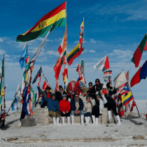 Flags of various countries flying at the Salar de Uyuni, Bolivia, with a group of travelers enjoying.