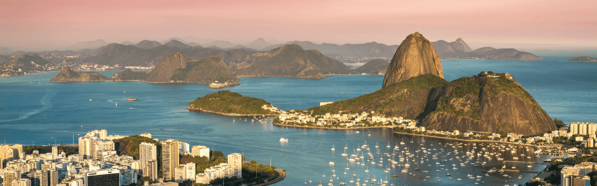 Paisaje de Río de Janeiro con la famosa montaña Sugarloaf y la bahía en tonos rosados y azules.