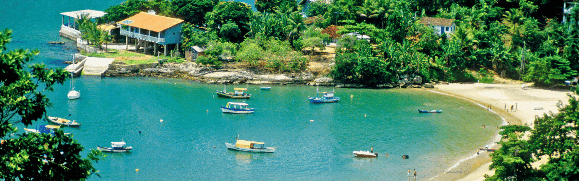Bahía con barcos y vegetación en un entorno tropical, ideal para actividades acuáticas y relajaci.