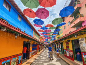 Suelos coloridos y paraguas flotantes en un vibrante callejón urbano en El Kaminante.
