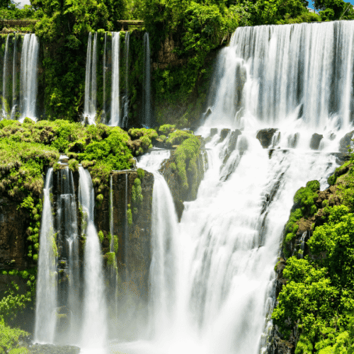 Cascada en un entorno natural con abundante vegetación y agua cristalina.