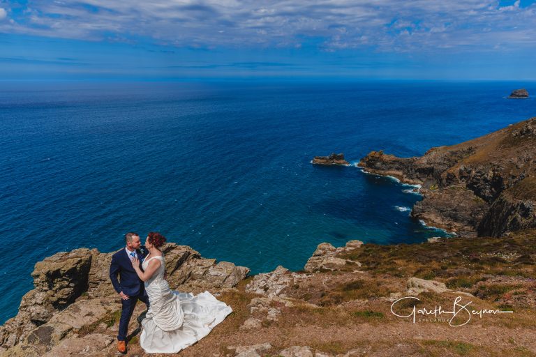 Devon wedding photographer eyecandy photography and venue name capturing a couple on a cliff edge overlooking the sea.