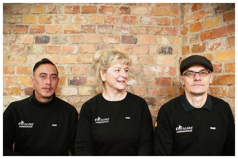 Team bei Fahrradhaus Pötschke Teamfoto vor einer Backsteinwand bei Fahrradhaus Pötschke.