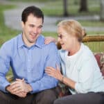 Senior woman chatting with adult nephew on patio