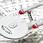 Star Trek USS Enterprise model placed on architectural blueprints, symbolizing innovation and strategic planning.