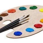 Vivid artist's palette with colorful paint blobs and fine brushes, symbolizing creativity; suitable for legal services emphasizing personalized solutions.